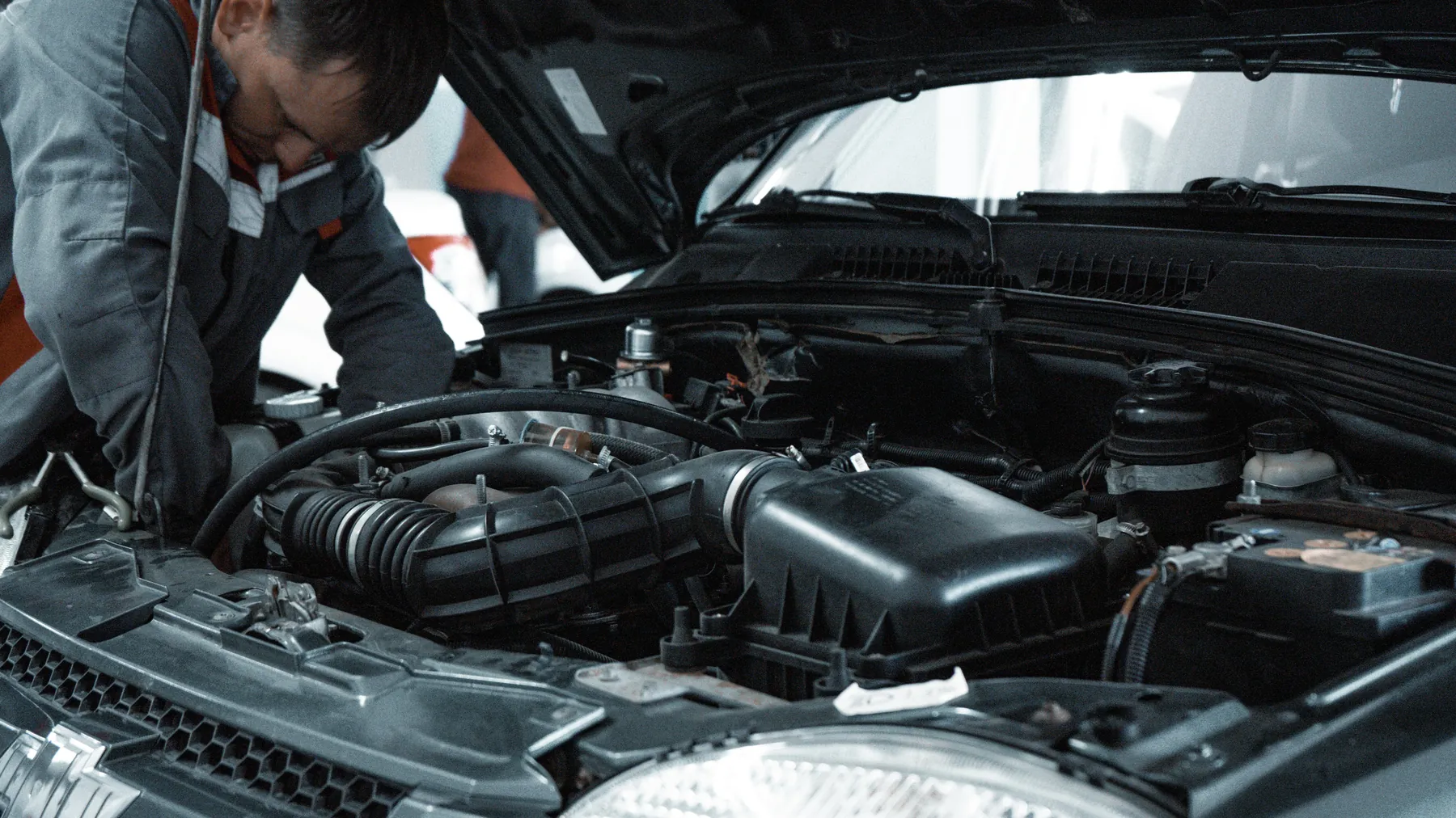 Automotive technician inspecting a car engine before delivery