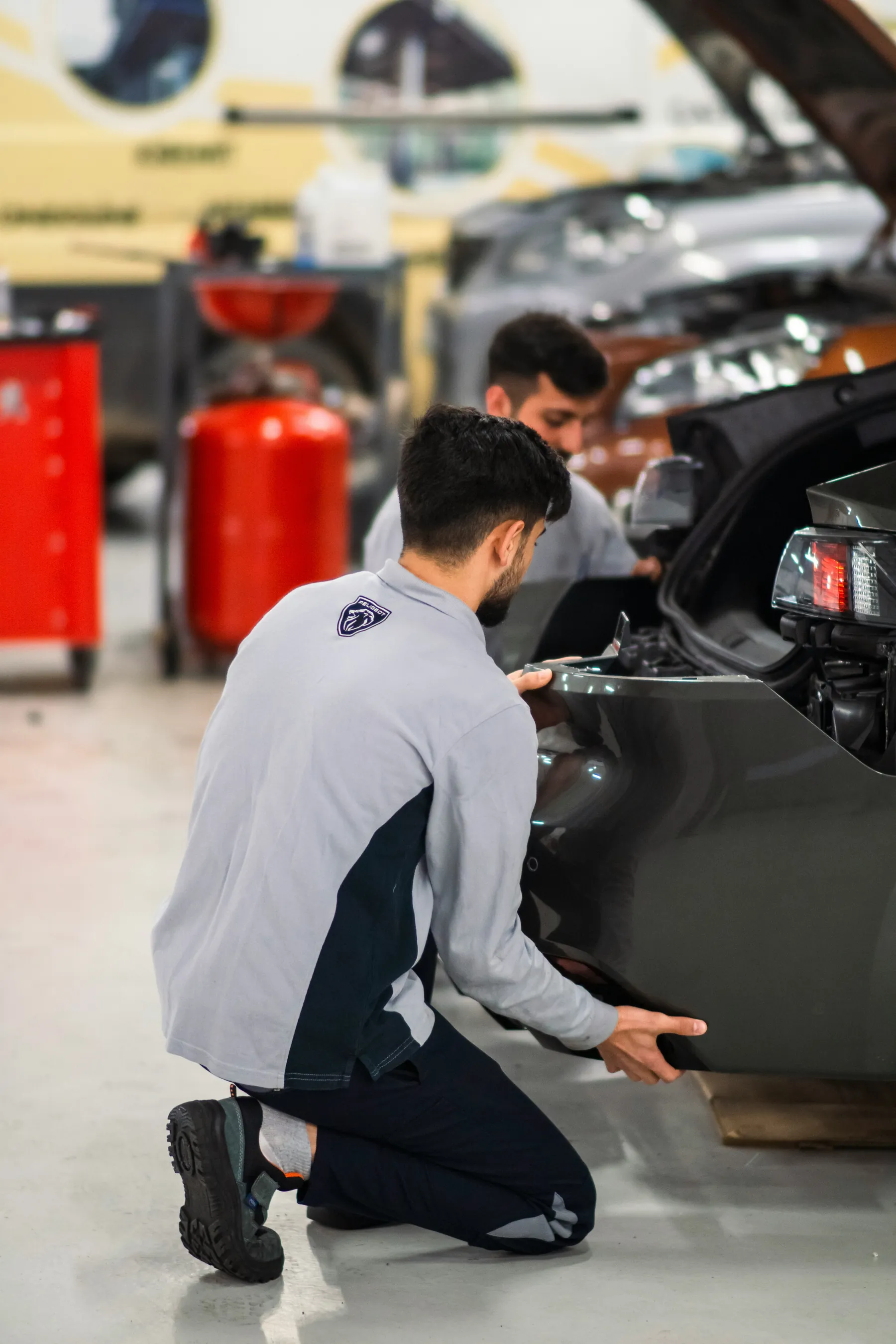 Technicians visually checking a rear body panel