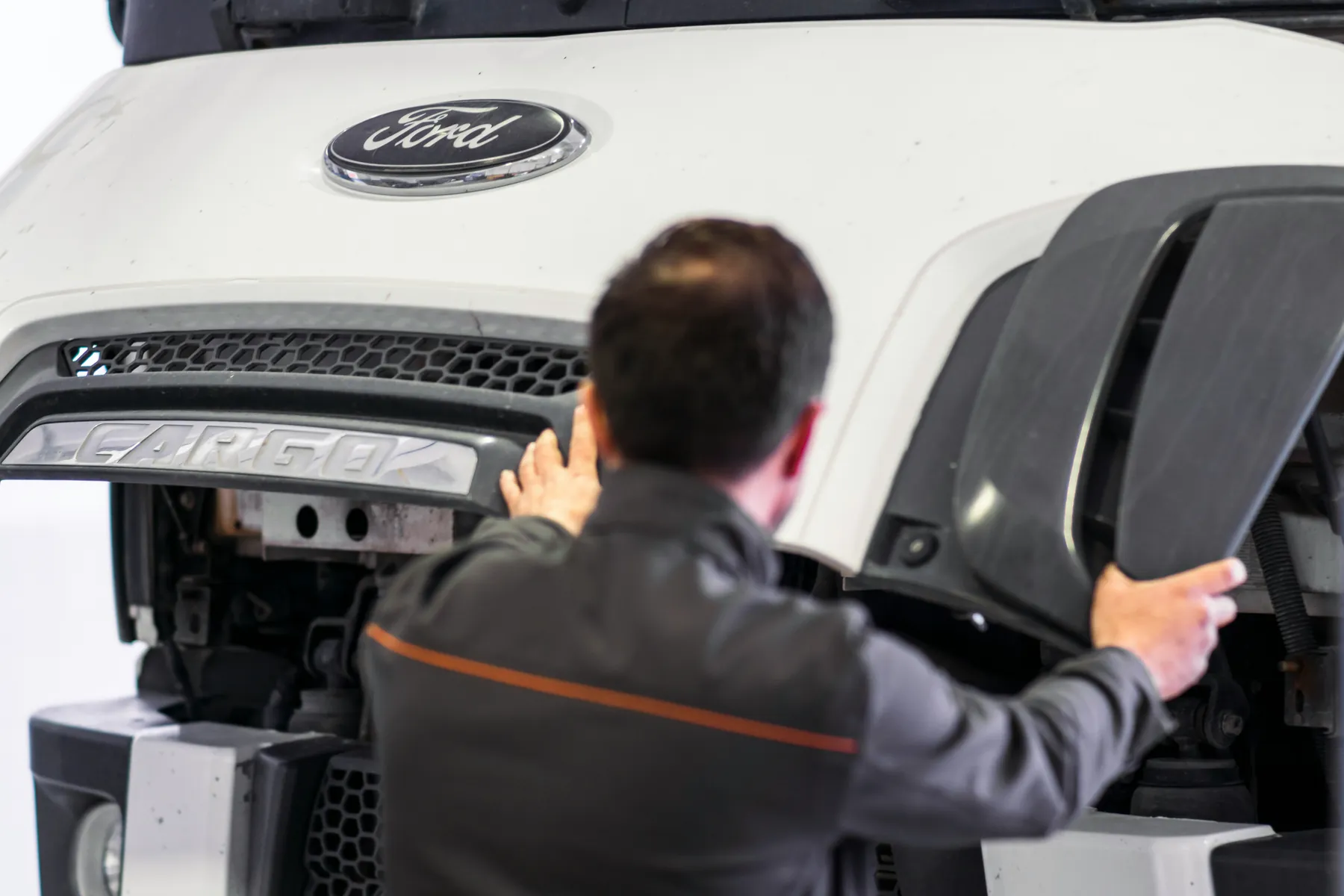 Technician inspecting front bumper components