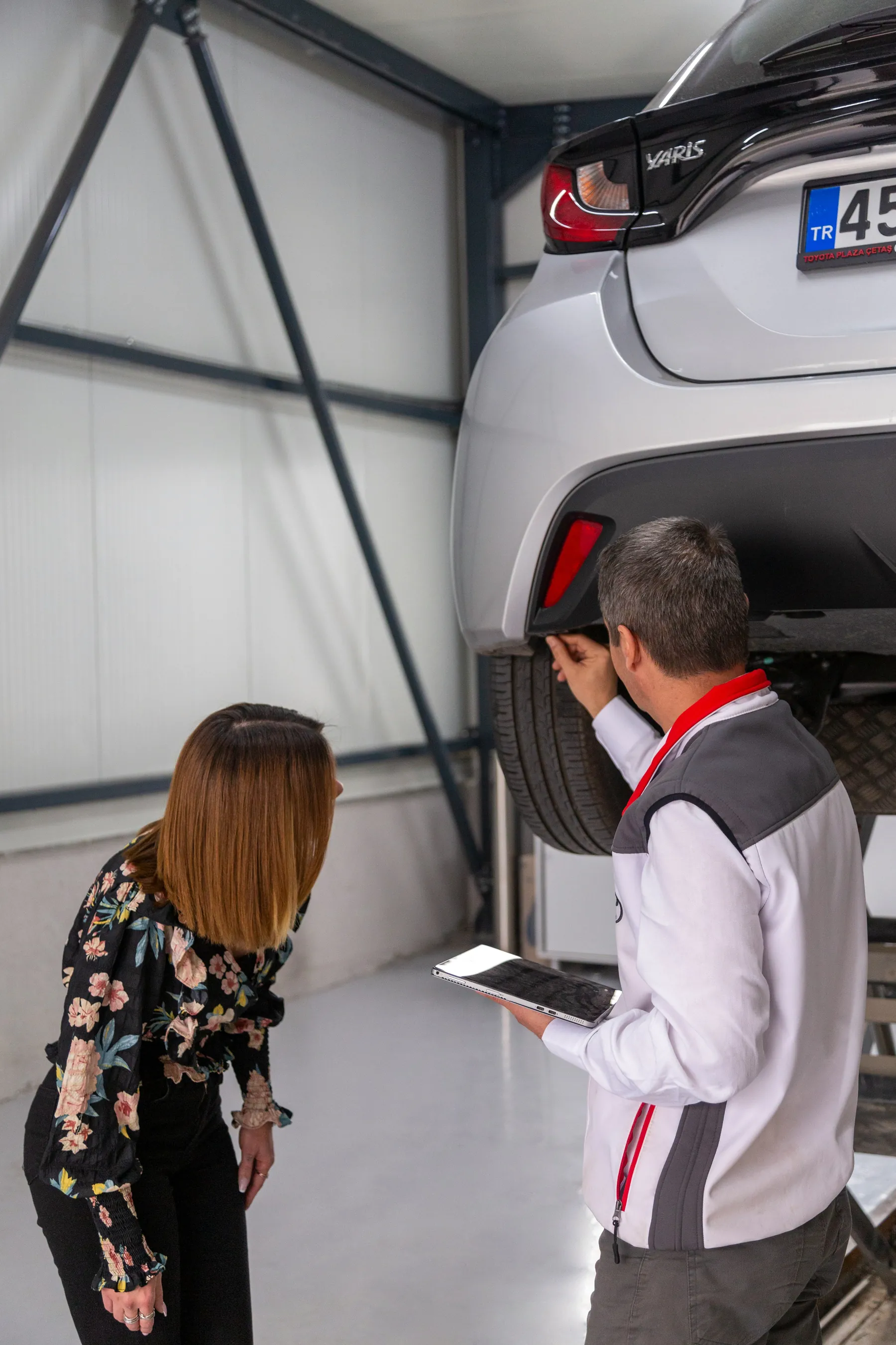 Technician inspecting the underside of a raised vehicle